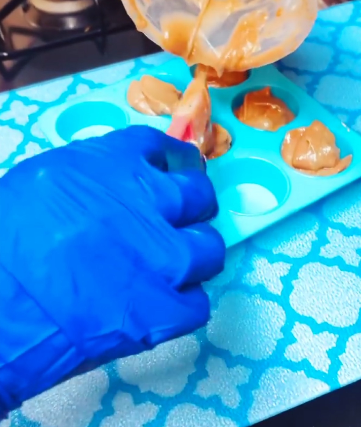 Ariella hand-pouring fresh soap batter into molds